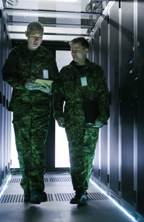 Men in military uniform walking in data center